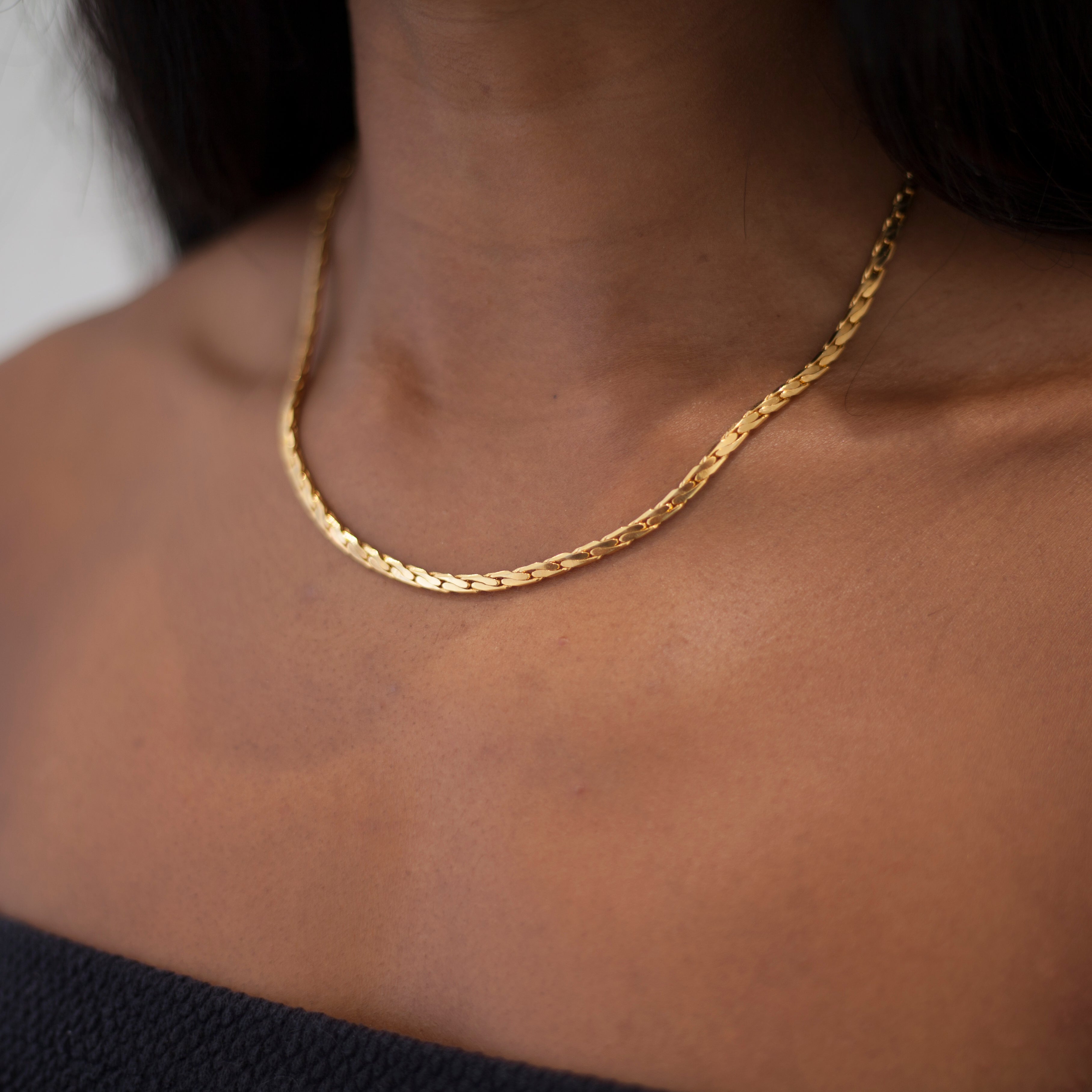 Gold tight link chain necklace on model