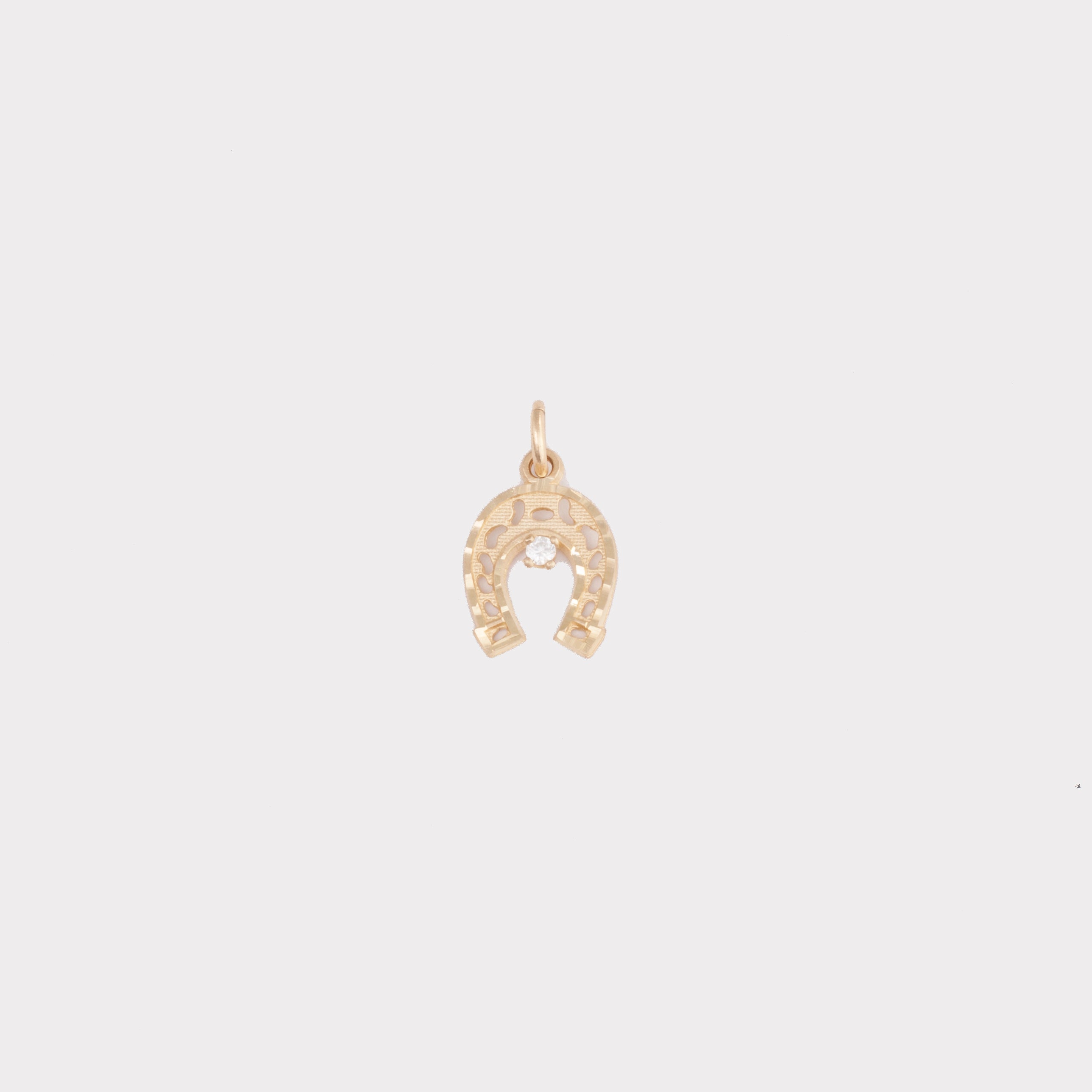 Horseshoe charm with diamond-cut detailing with small cubic zirconia (CZ) stone in the centre.
