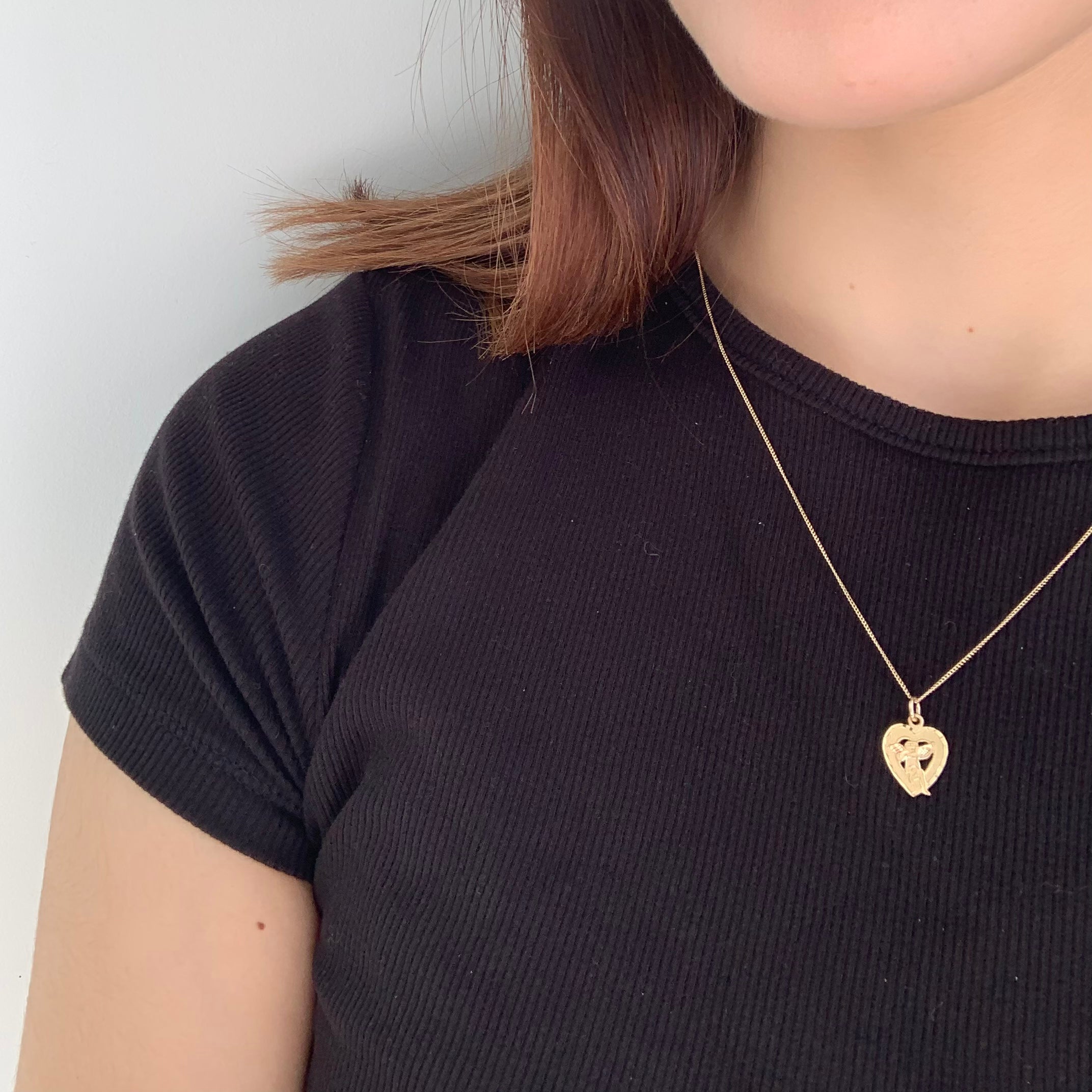 Cherub Angel sitting in a heart-shaped pendant on figure