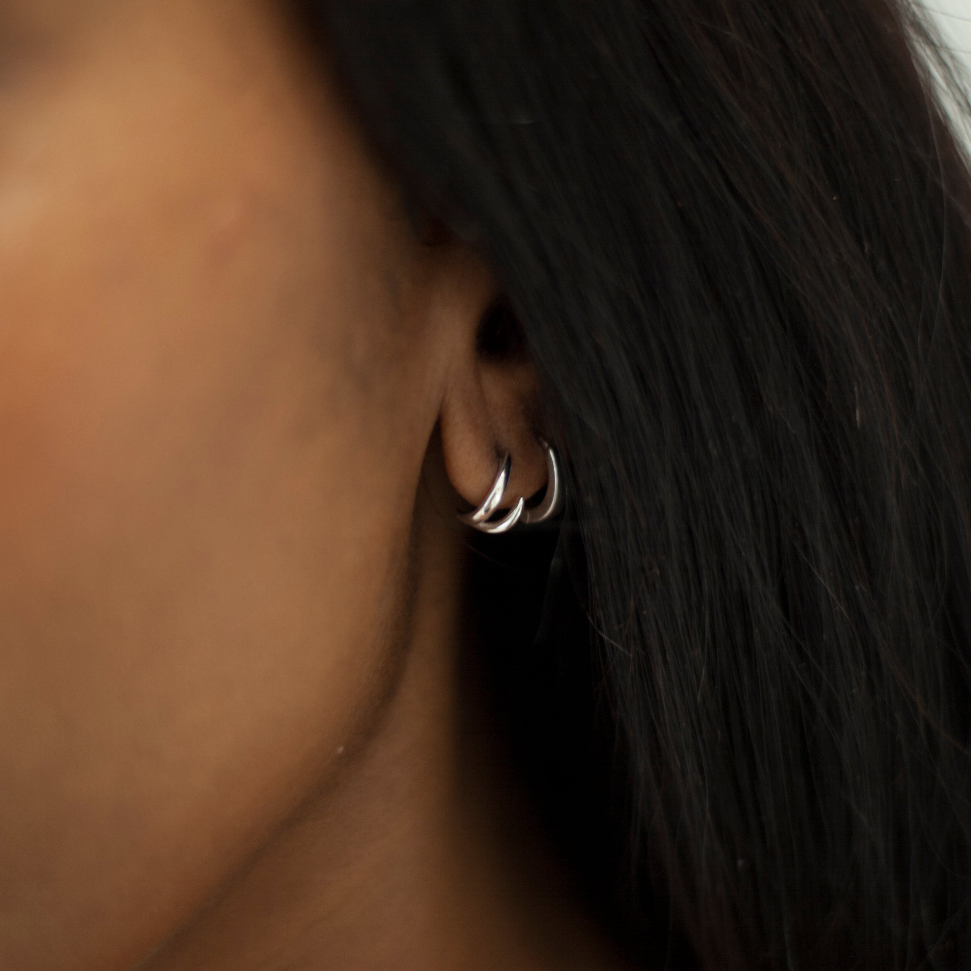 Silver claw stud earrings on model