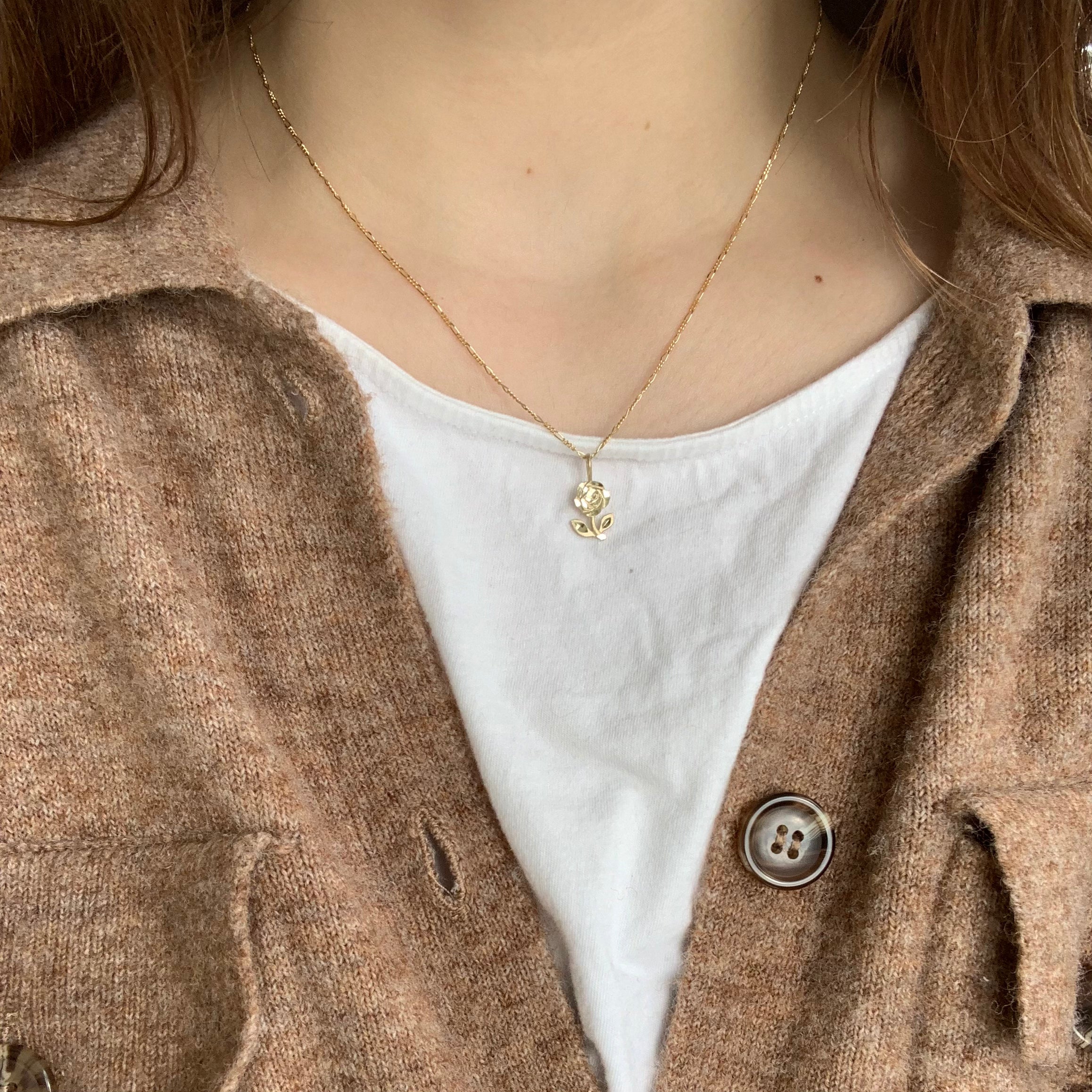 10k yellow gold flower pendant with diamond cut details on a thin figaro chain