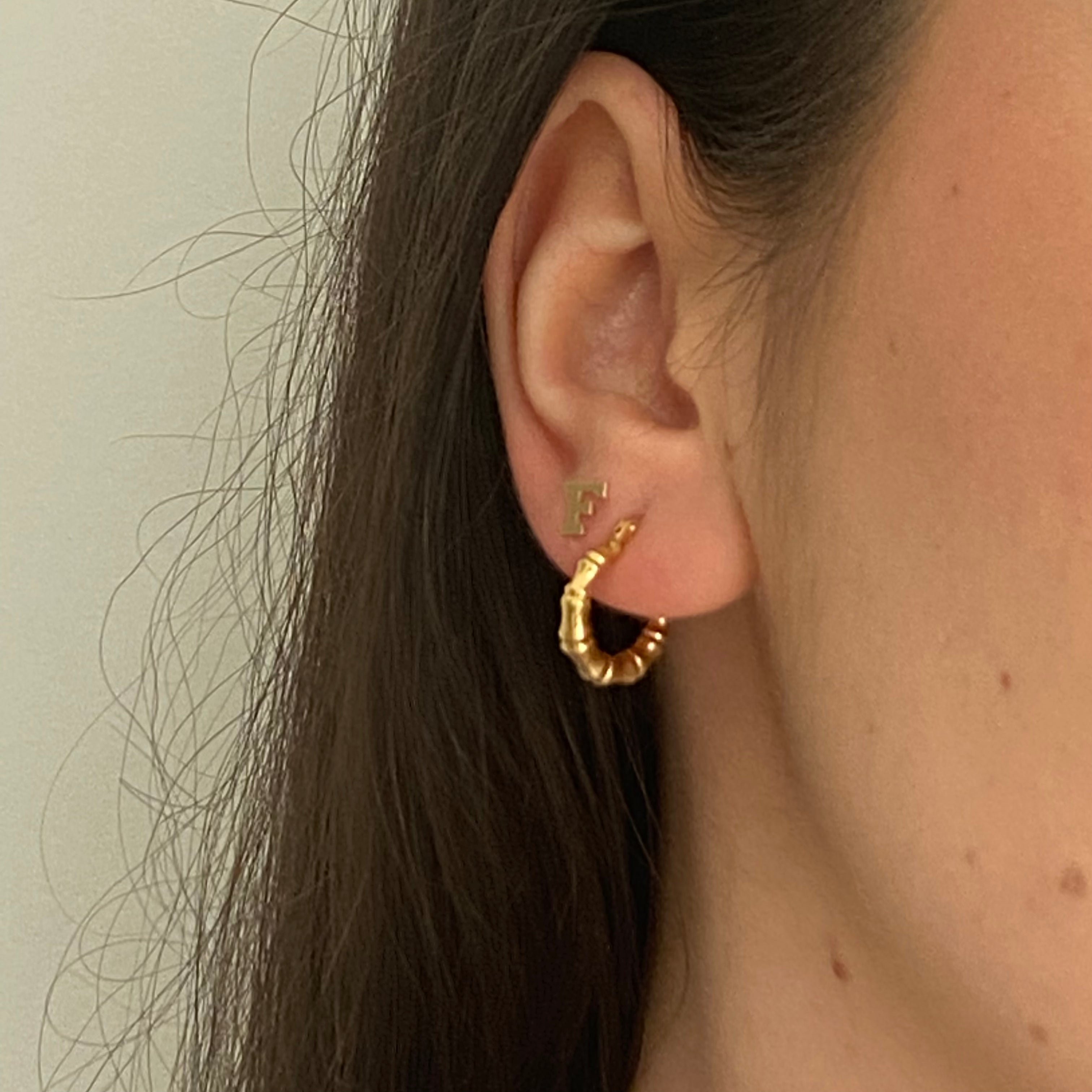 14k yellow gold Hollow Hoops with Bamboo Detail. Paired with our Block Letter Stud Earring.