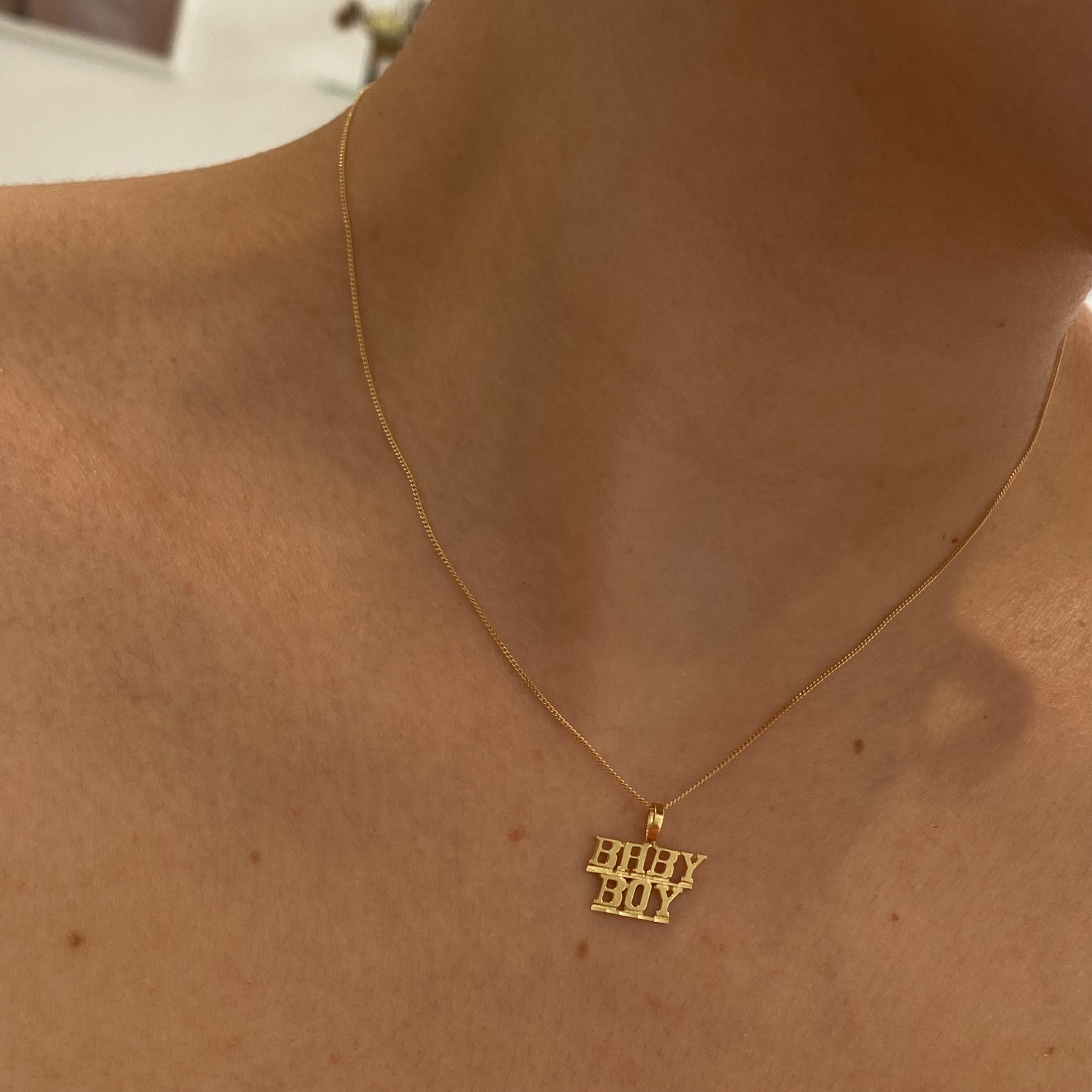 model wearing 10K Gold 'Baby Boy' pendant on a thin curb chain