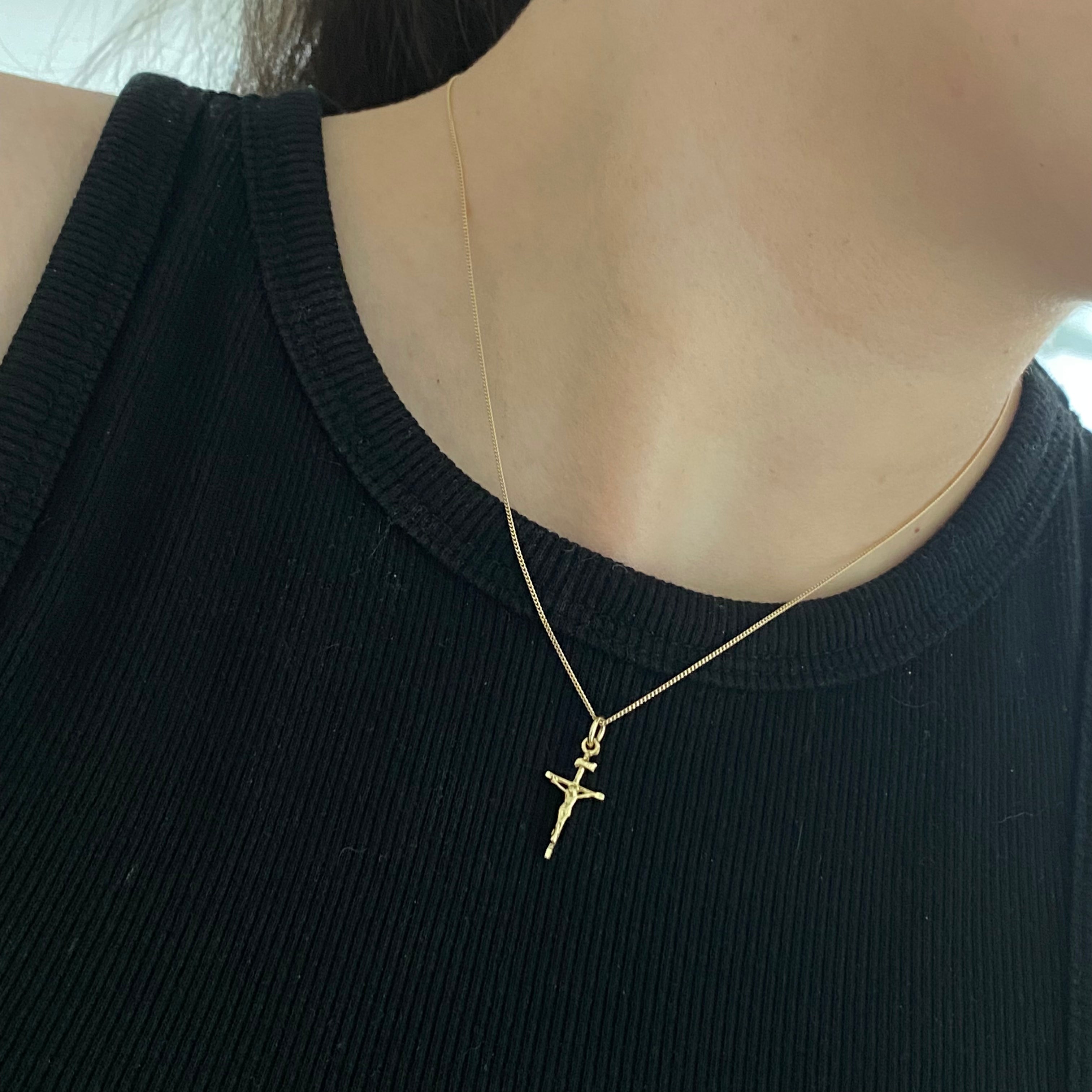 Gold crucifix pendant on thin curb chain