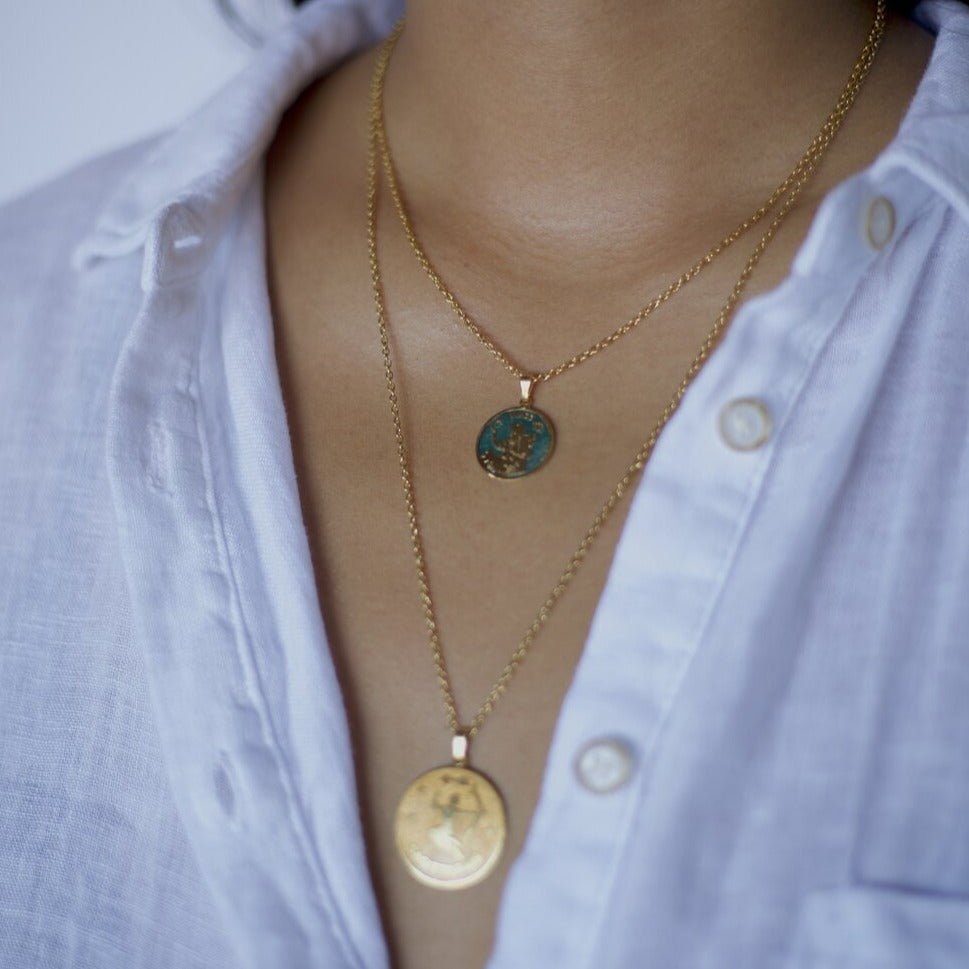 model wearing 2 zodiac pendants